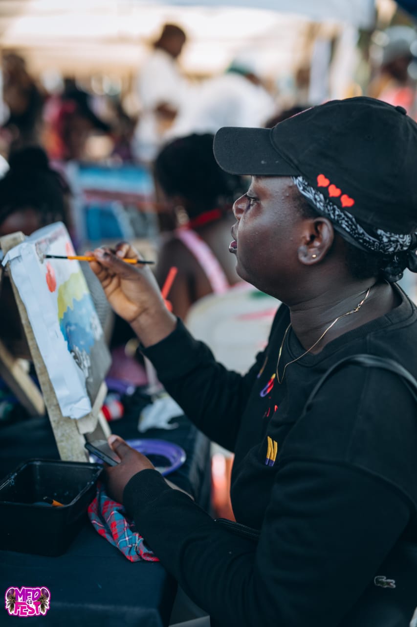 A guest painting on canvas at MedFest